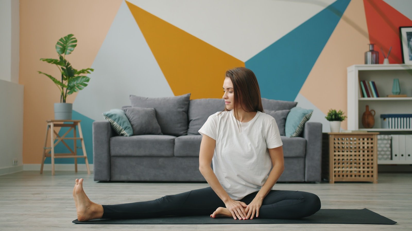 Woman following a beginner-friendly stretching routine on a mat at home
