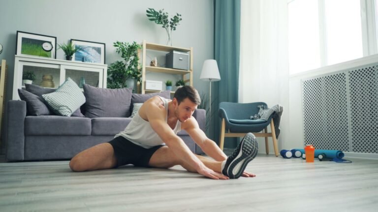 Young man stretching at home in a modern living room setting.